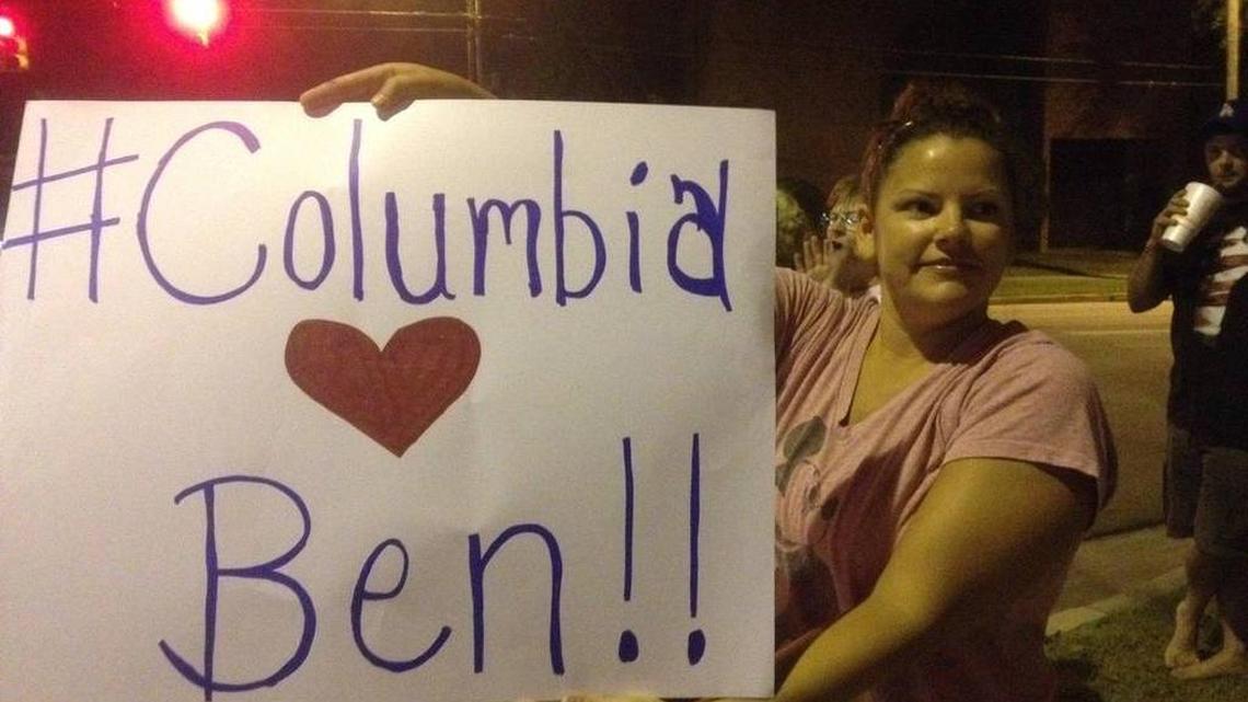 
In this file photograph, Kelli Feathers holds up a sign to show her support for anchorman Ben Hoover, after his contract with WIS was not renewed in 2014.
