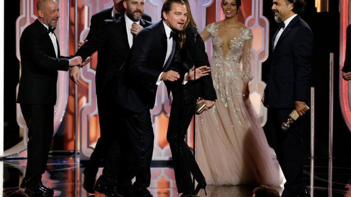 In this image released by NBC, Leonardo DiCaprio, center, appears on stage with the cast and crew of "The Revenant," after the film won best motion picture drama during the 73rd Annual Golden Globe Awards at the Beverly Hilton Hotel in Beverly Hills, Calif., on Sunday, Jan. 10, 2016. DiCaprio also won for best actor in a motion picture drama.