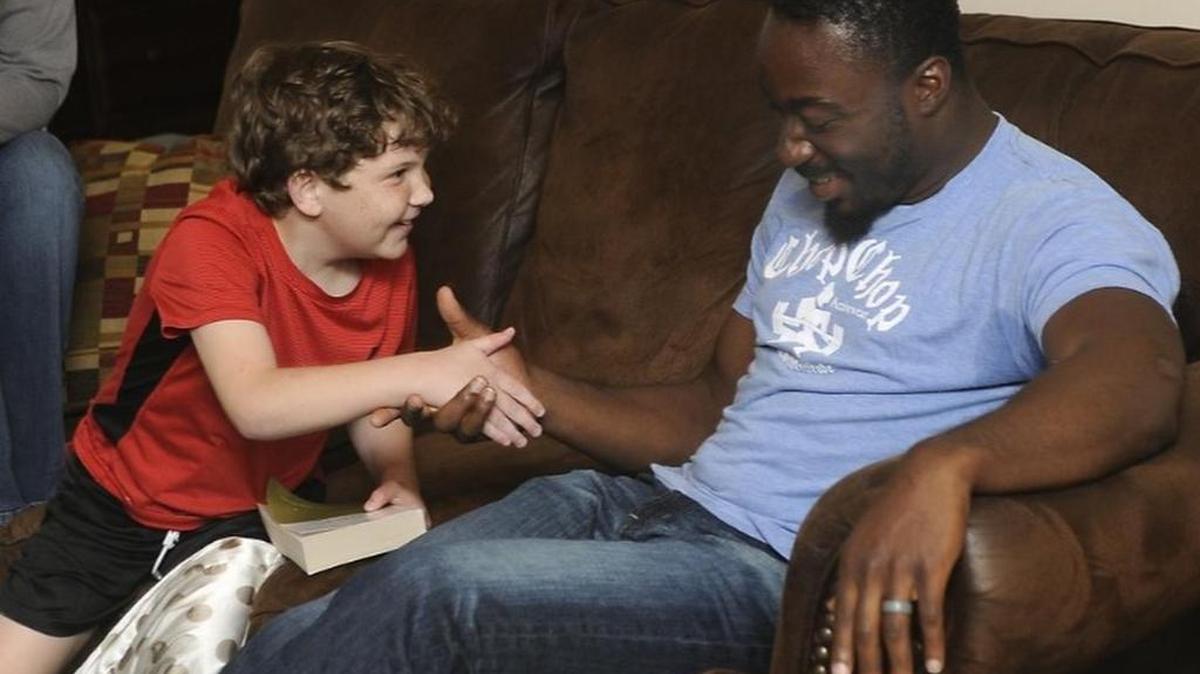 Tyler Shelley, 11, left, meets former USC football star Marcus Lattimore Friday evening after Lattimore dropped by to help Tyler come up with a plan to distribute Bibles to shelters and soup kitchens.