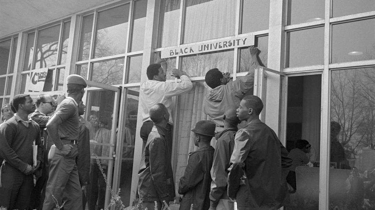 Students place a “black university” sign over the administration building’s front door at Howard University.