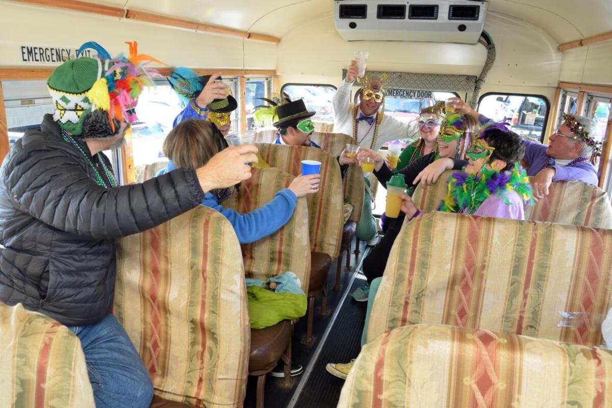 A crowd gathers to parade through the Rosewood area of Columbia to participate in, watch or follow the 2016 Mardi Gras Parade and celebration on Feb. 6, 2016. Here, members of the Krewe du Vieux Bois, or Crew of the Woods, toast as they travel on the Captain Telegram Trolley in the parade.
