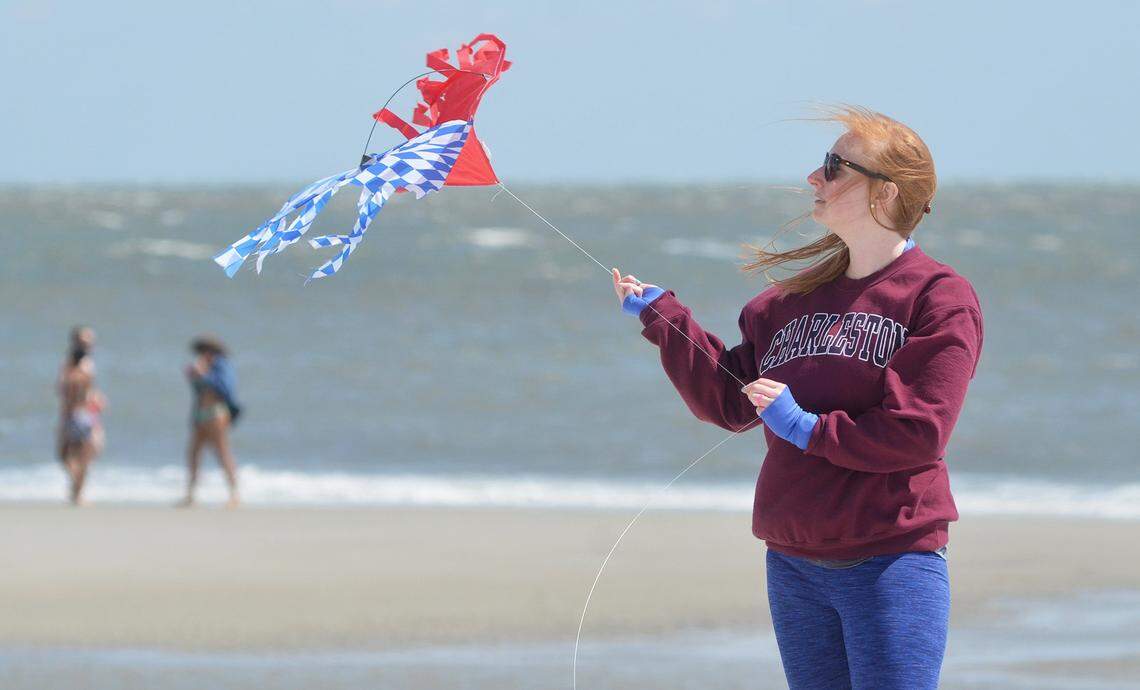 Whitney Tesh of Charlotte helps her husband, Justin, not pictured, launch a kite into the ocean breeze at Hilton Head Island's Coligny Beach Park.