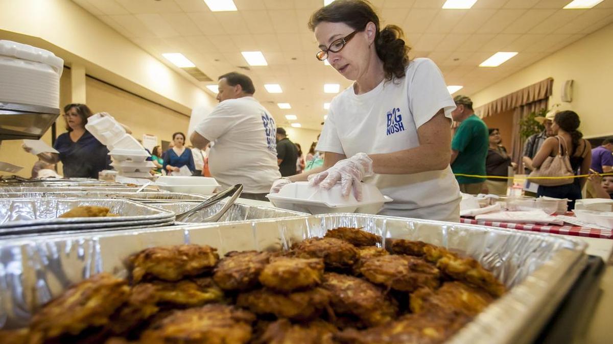 
Rebecca Coffman prepares meals including fried latkes, foreground, at the Big Nosh Tree of Life Jewish Cultural Festival.
