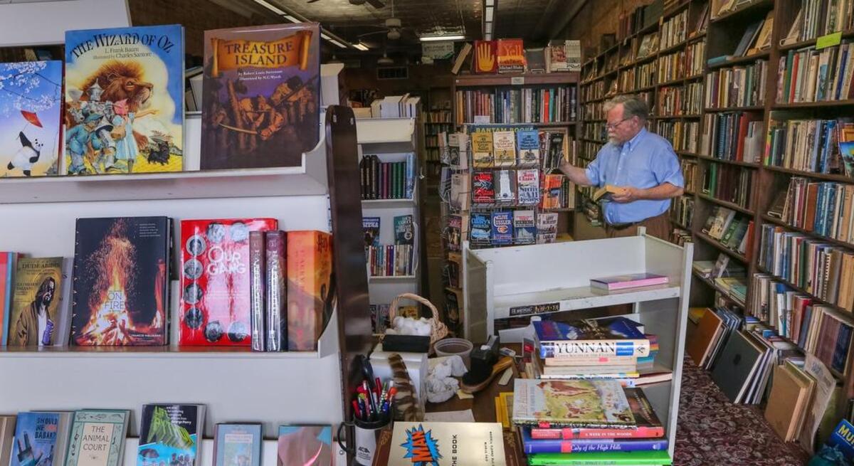Bill Higgins sorts books at Ed’s Editions book store on Meeting Street.