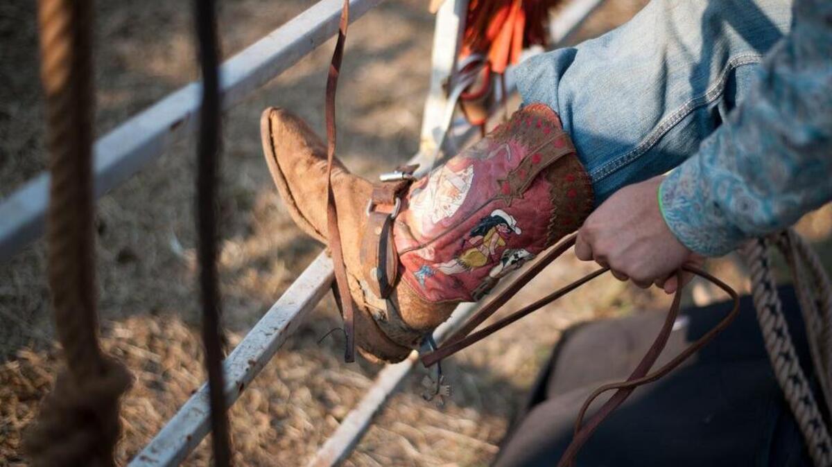 A rider readies his boots before taking a ride on a bull during a past Blythewood rodeo.