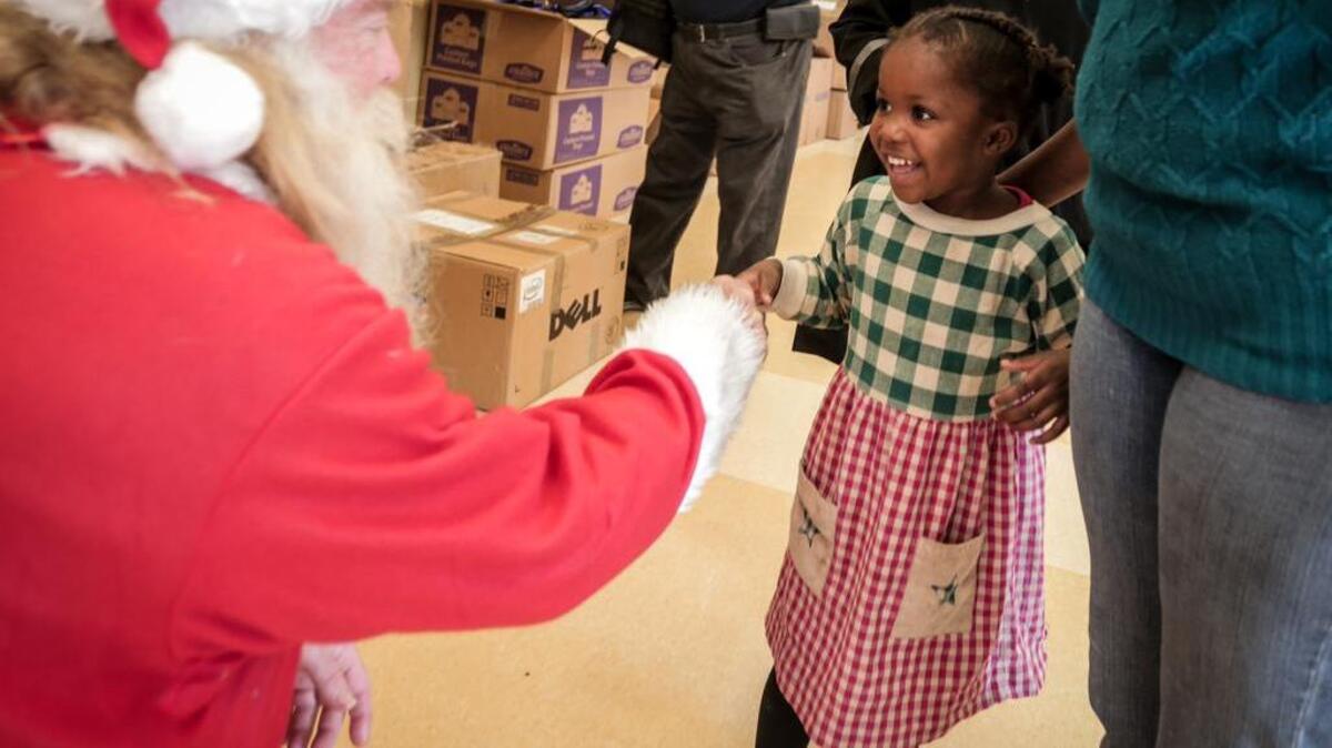 Loveley Brown meets Santa on Christmas morning last year during St. Peter’s Church’s annual Christmas Feast.