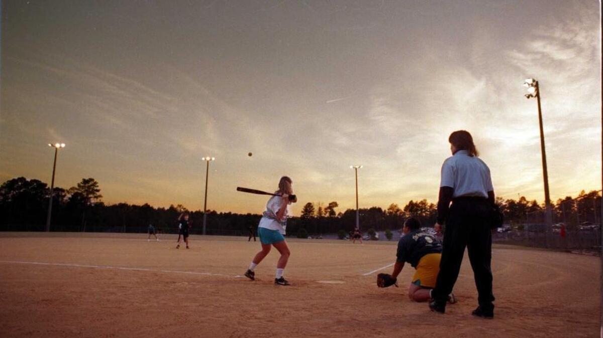 Adults play softball in Lexington at Pine Grove softball complex.