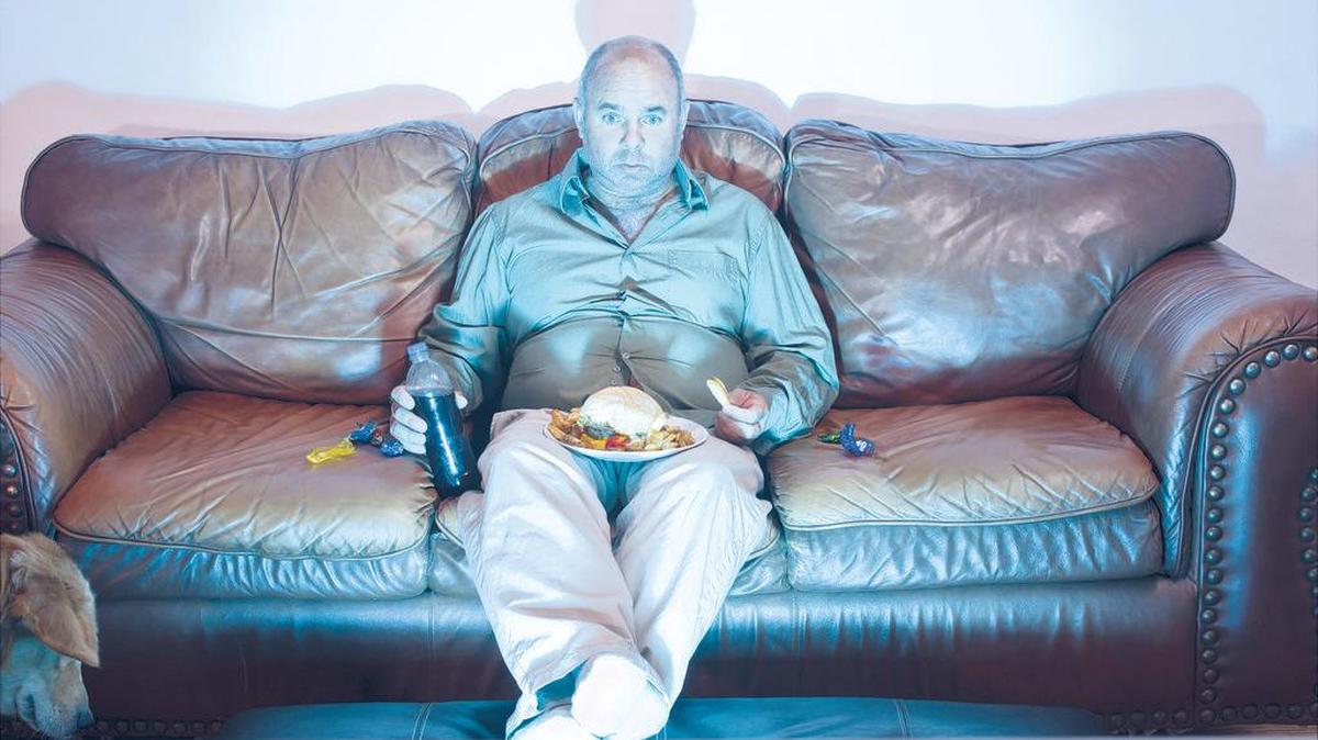 A man sitting on a couch watching TV.