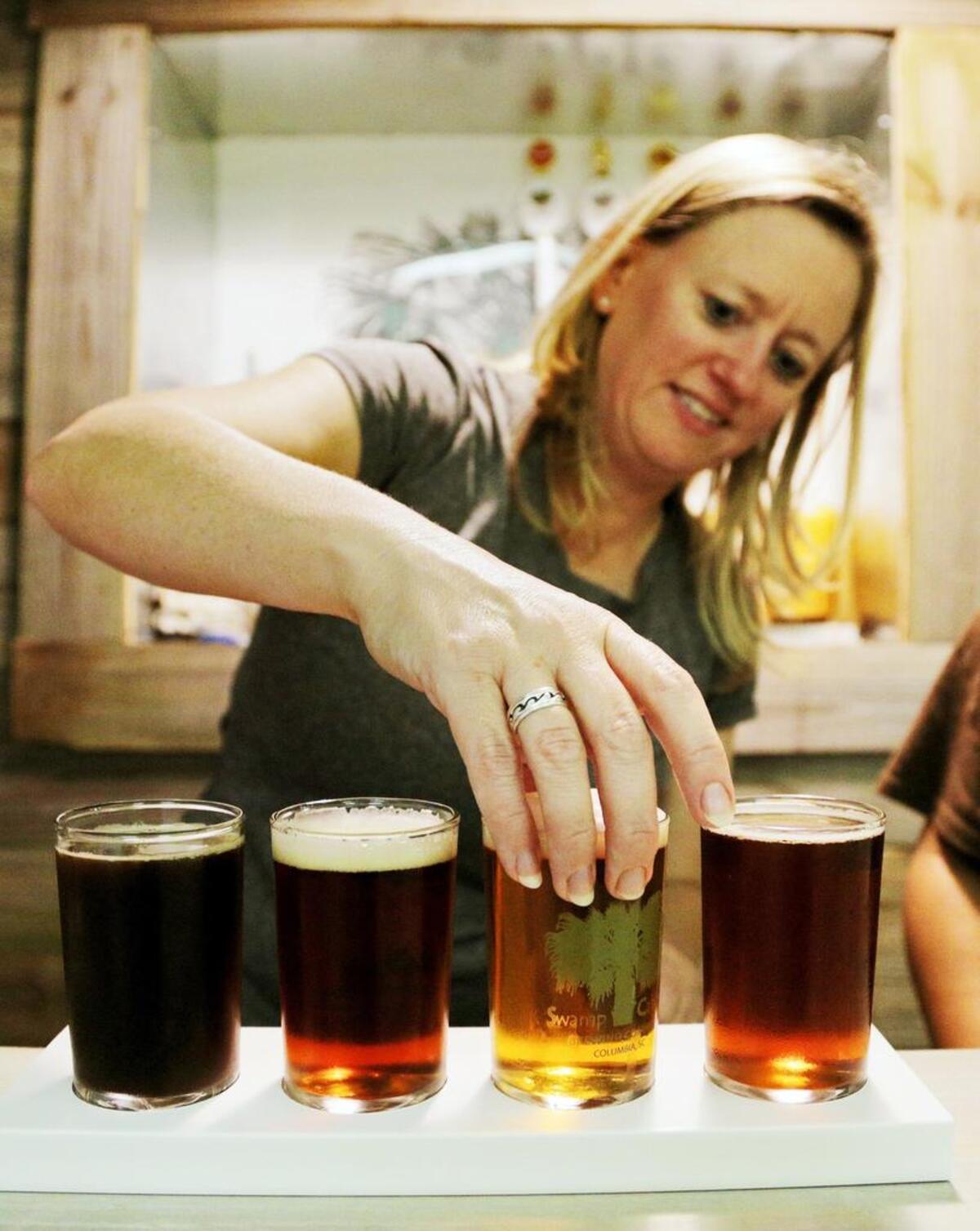 Swamp Cabbage Brewing Company's Karen Steele finishing pouring a flight of beers for a customer, Thursday, October 2, 2014.