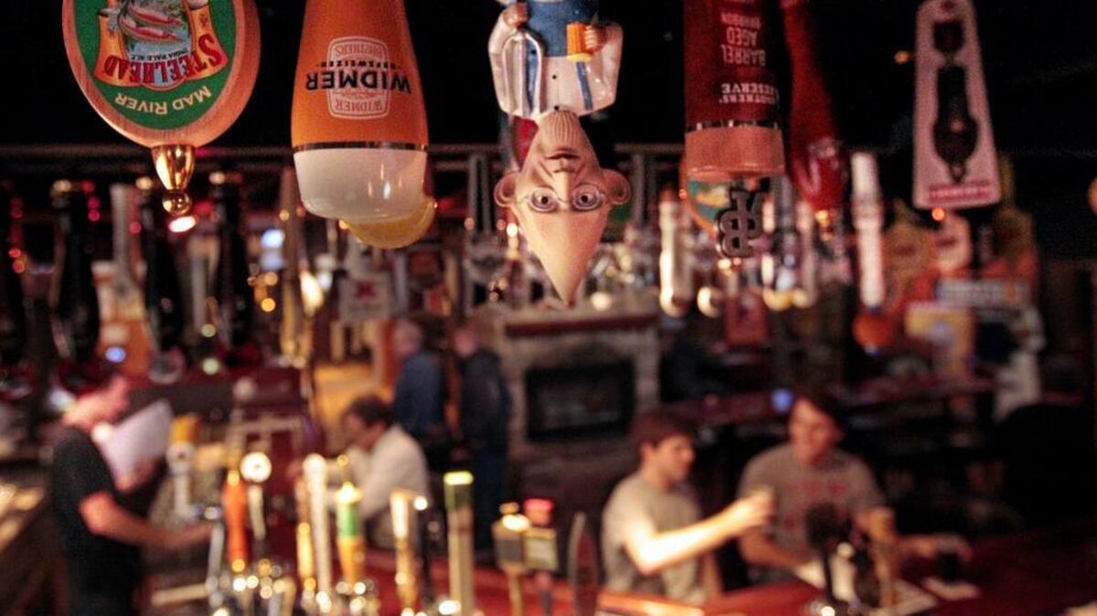 Tap handles hang from the ceiling as folks enjoy a variety of beers at World of Beer. The Vista bar has almost 600 beers available.