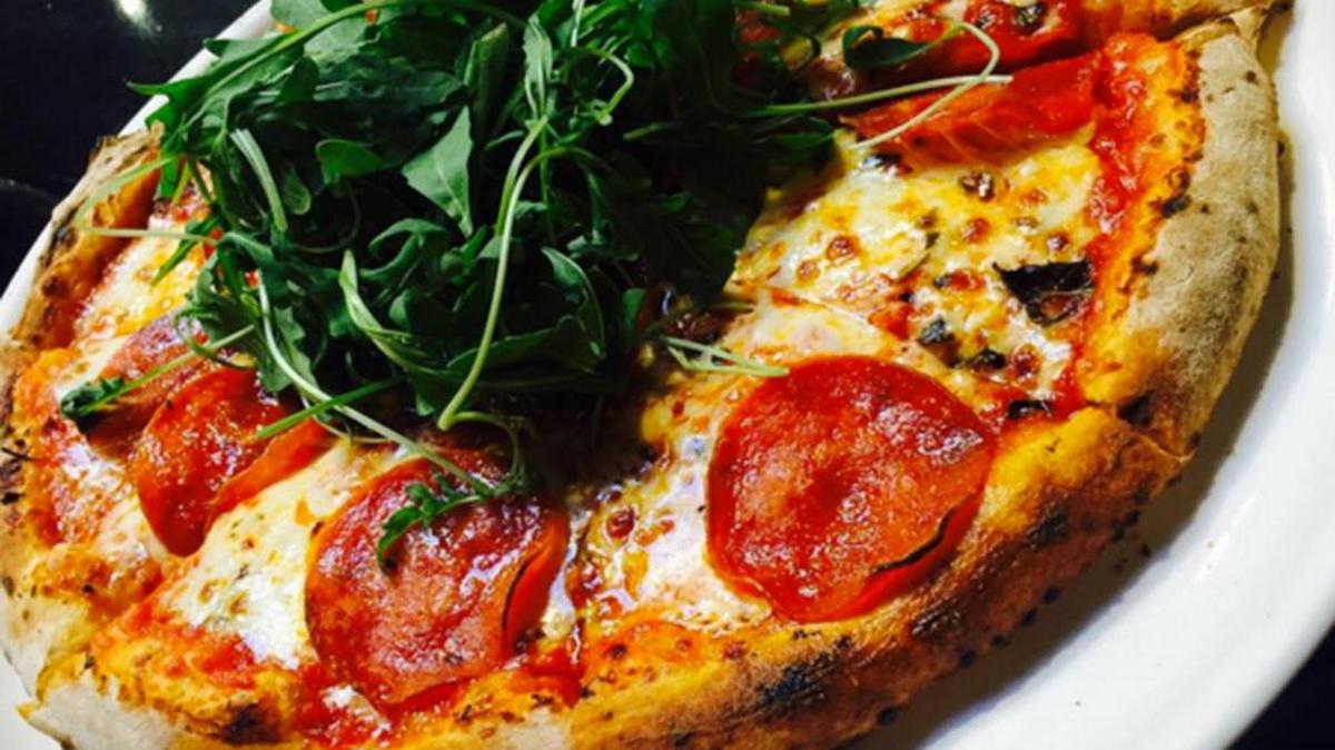 A marinara pizza topped with pepperoni and arugula at Persona.