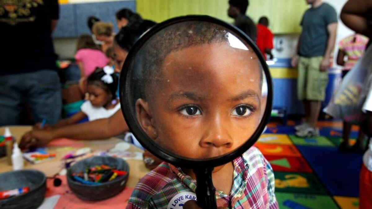 Mark Ross plays with a magnifying glass at a mock kindergarten class during a previous Countdown to Kindergarten at EdVenture.