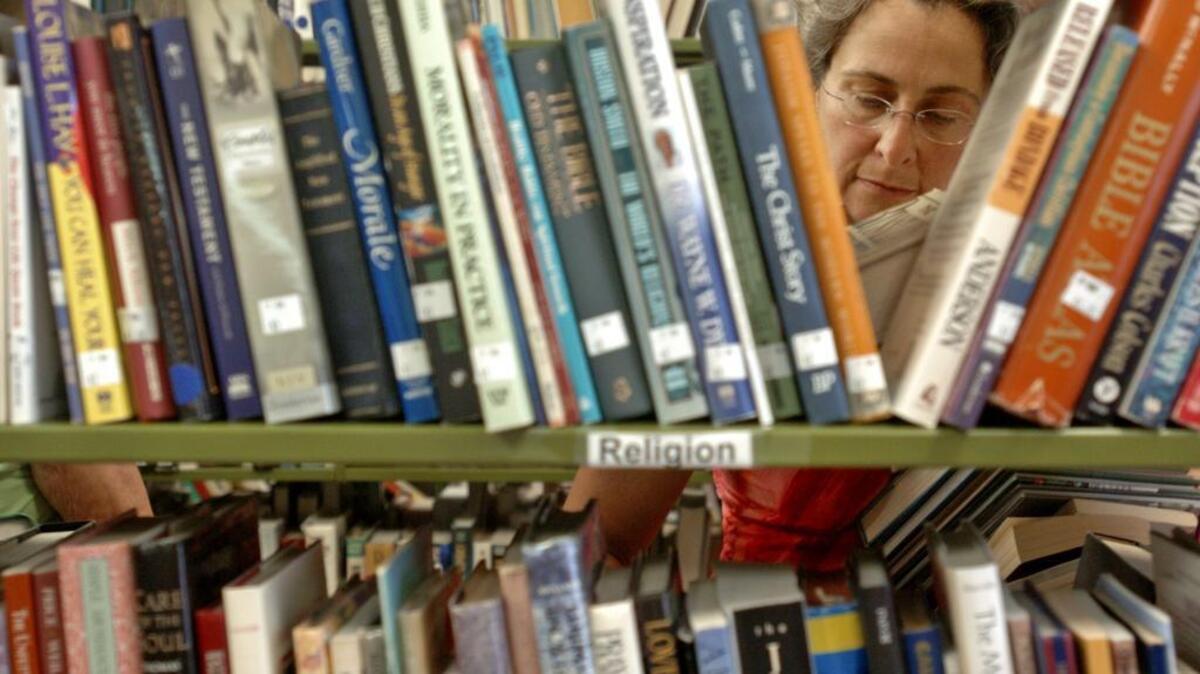 Shoppers look through books at a past sale.