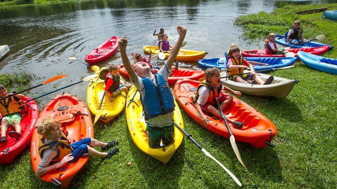 Campers cheer from their kayaks during a summer program at Heathwood Hall.