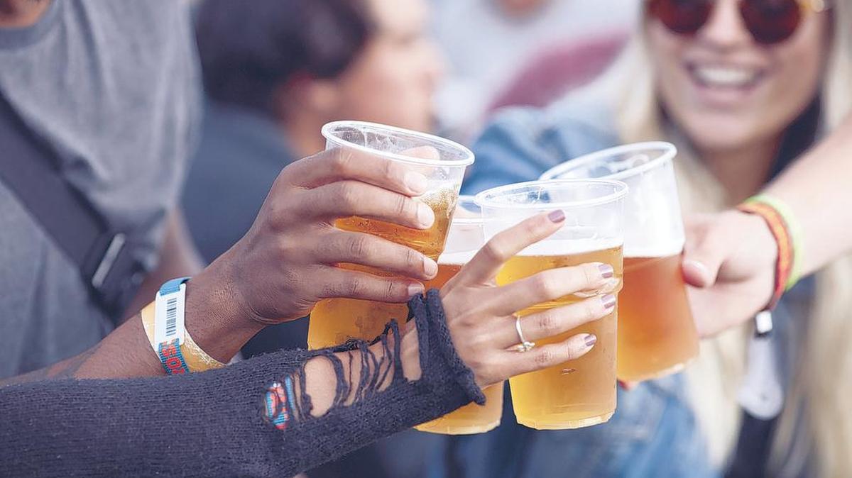 Close-up of hands toasting beer, at a festival.