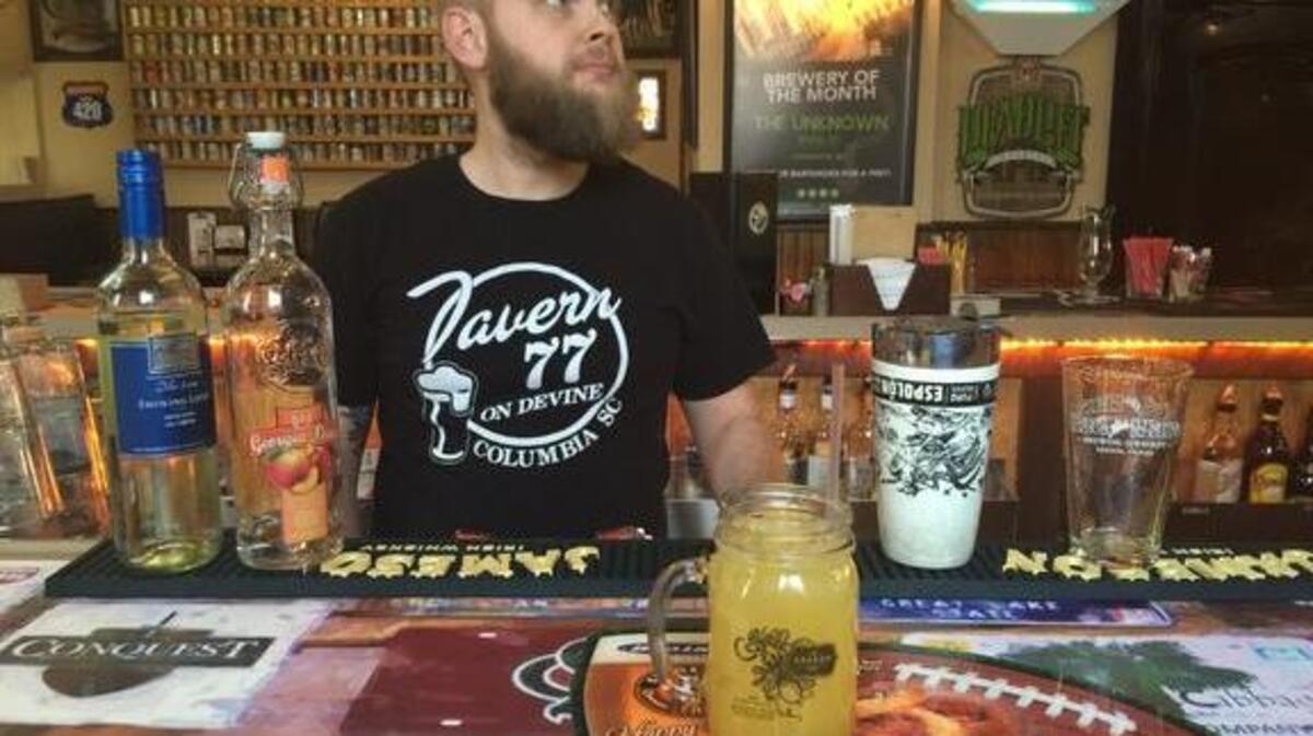 Bartender William Mills of Burger Tavern 77 pictured with their drink, the Peachy Keen