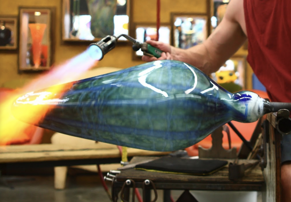 A glassblower at work at One Eared Cow Glass.