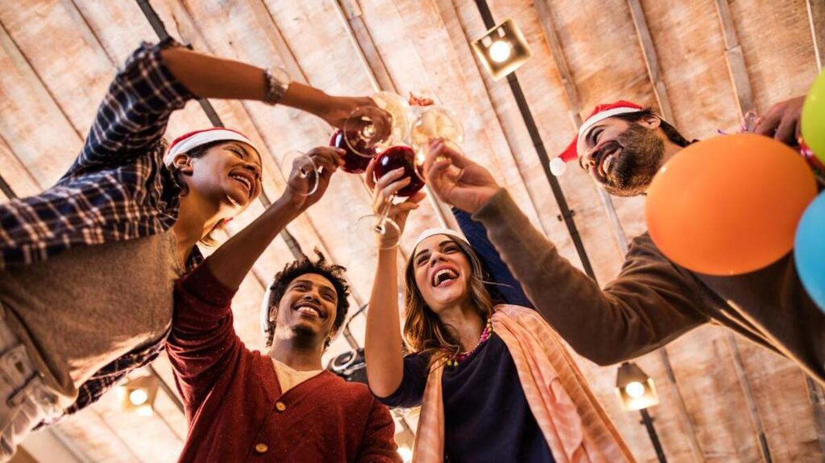 Low angle view of group of cheerful business people toasting to upcoming New Year.