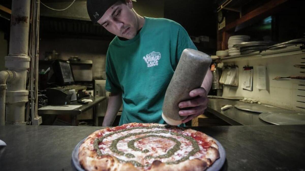 Zac James prepares a pizza at the Village Idiot in Five Points.