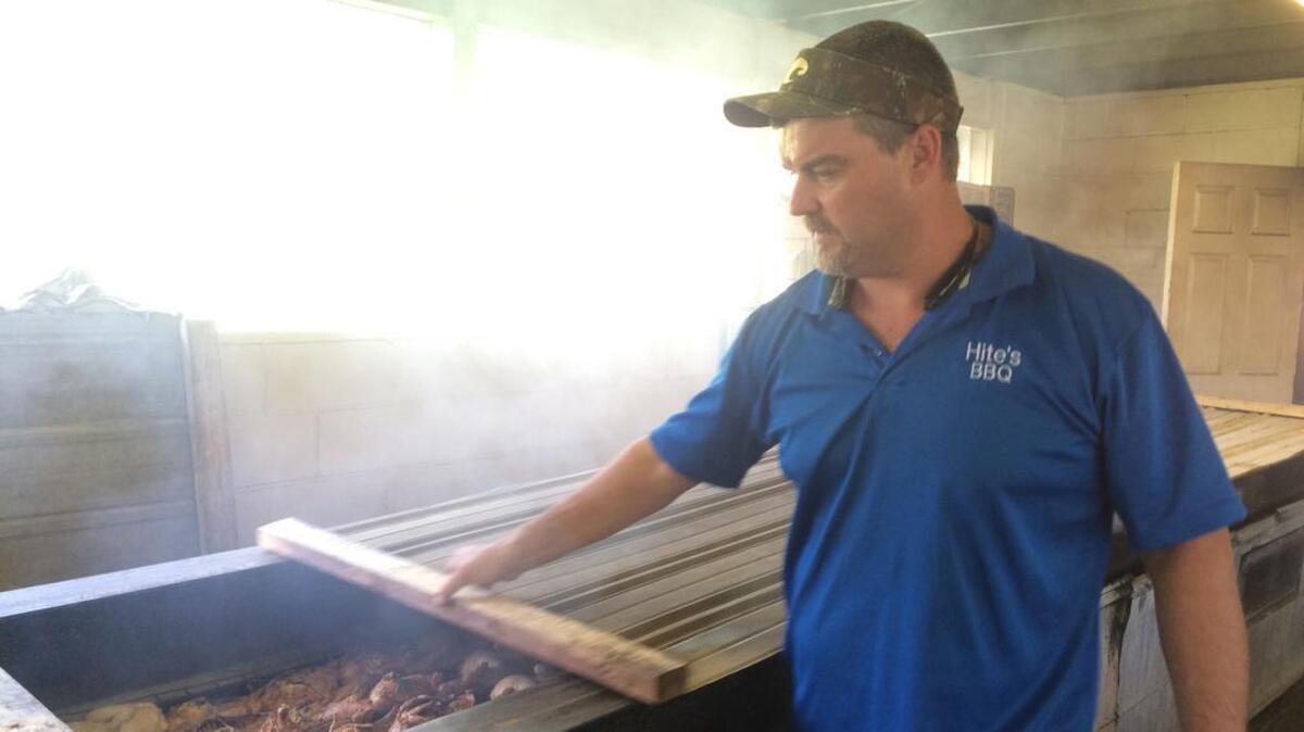 David Hite shows off the chicken he is preparing in the pits at Hite’s Bar-B-Que in West Columbia. In a typical weekend, the restaurant will serve 300-400 chickens.