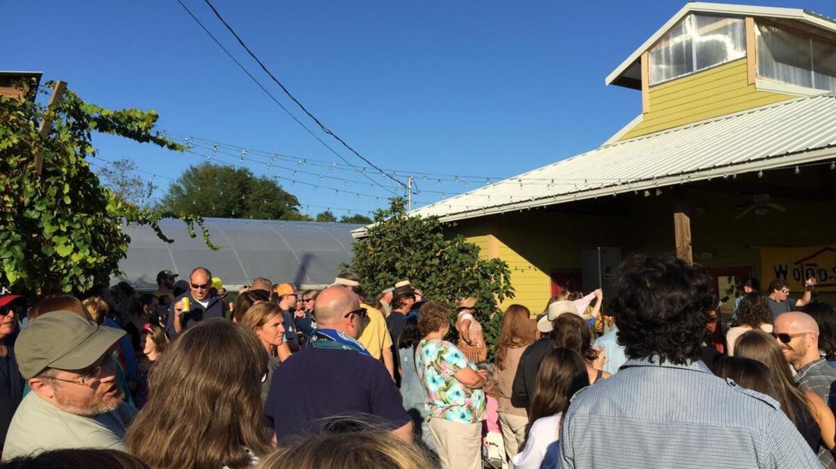 People gather outside City Roots in Rosewood after flooding last month.