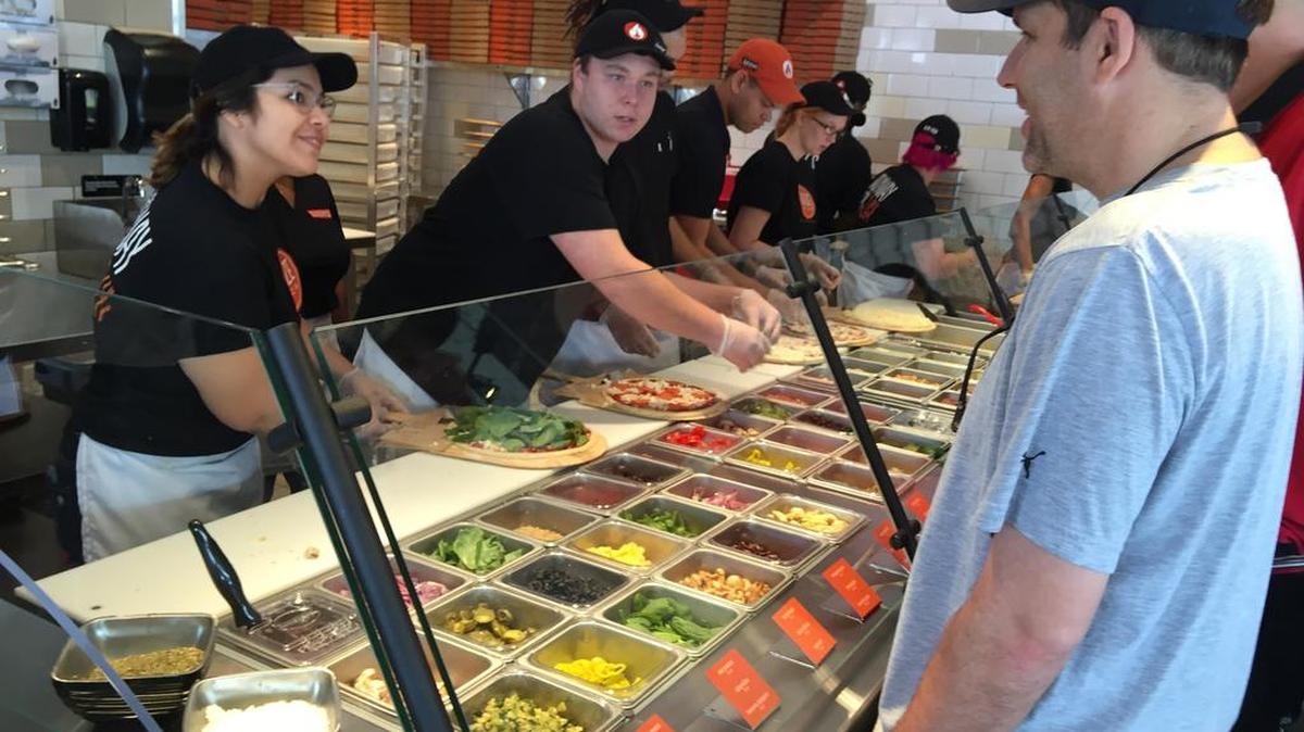 A customer orders a personal pizza at Blaze Pizza in Harbison.