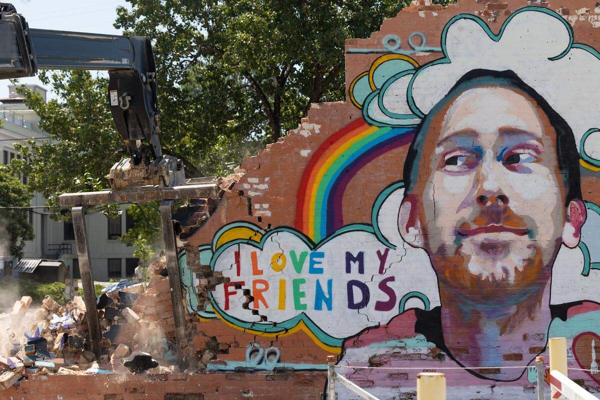 A mural of Aaron Graves, a local musician who died in 2019 of cancer, on the side of the Hunter-Gartherer location on South Main Street in Columbia, South Carolina is deconstructed on Saturday, June 28, 2025. Teams of volunteers assisted organizing pieces of the building for resale, and helped preserving the mural of Aaron Graves, a local musician who died of cancer in 2019.