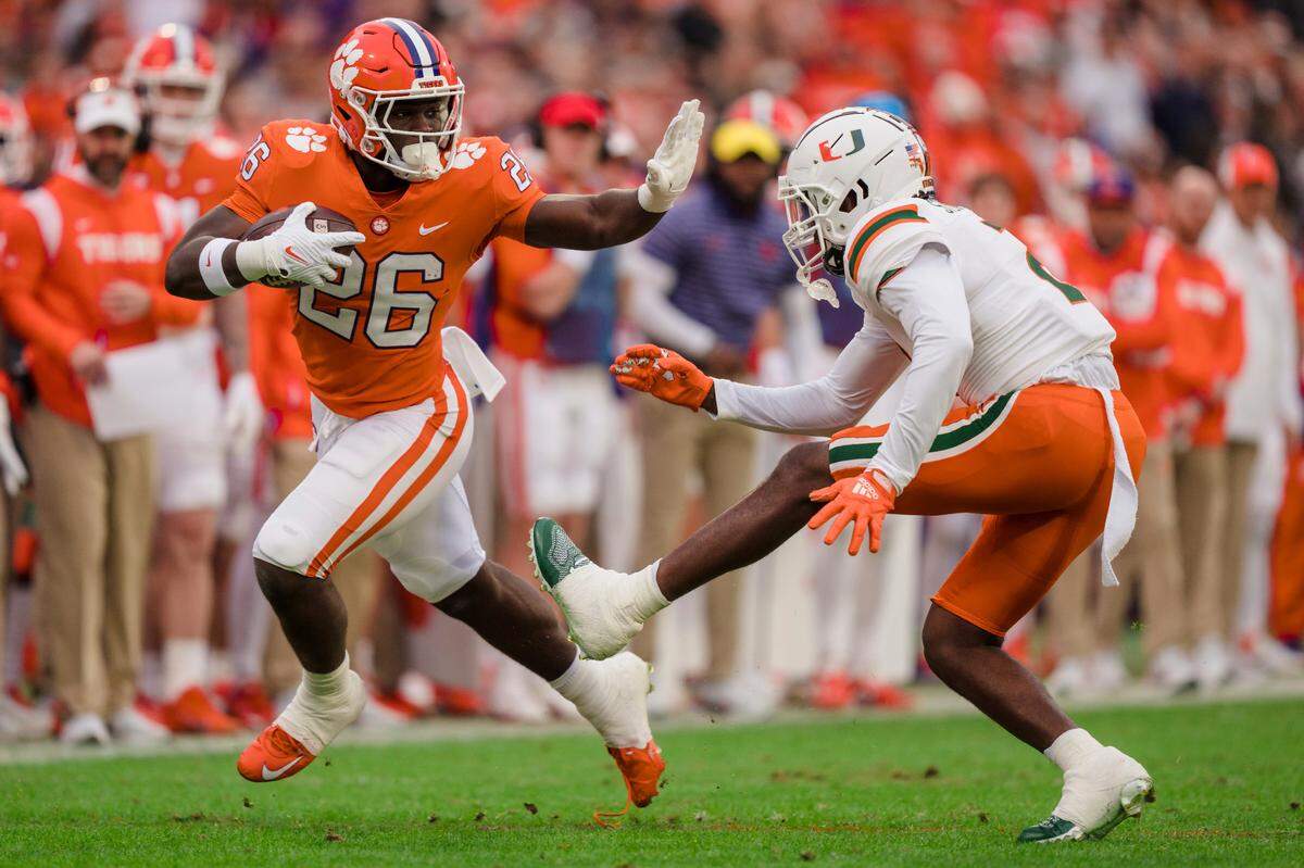 Clemson running back Phil Mafah (26) is pursued by Miami cornerback Tyrique Stevenson in the first half of an NCAA college football game on Saturday, Nov. 19, 2022, in Clemson, S.C. (AP Photo/Jacob Kupferman)