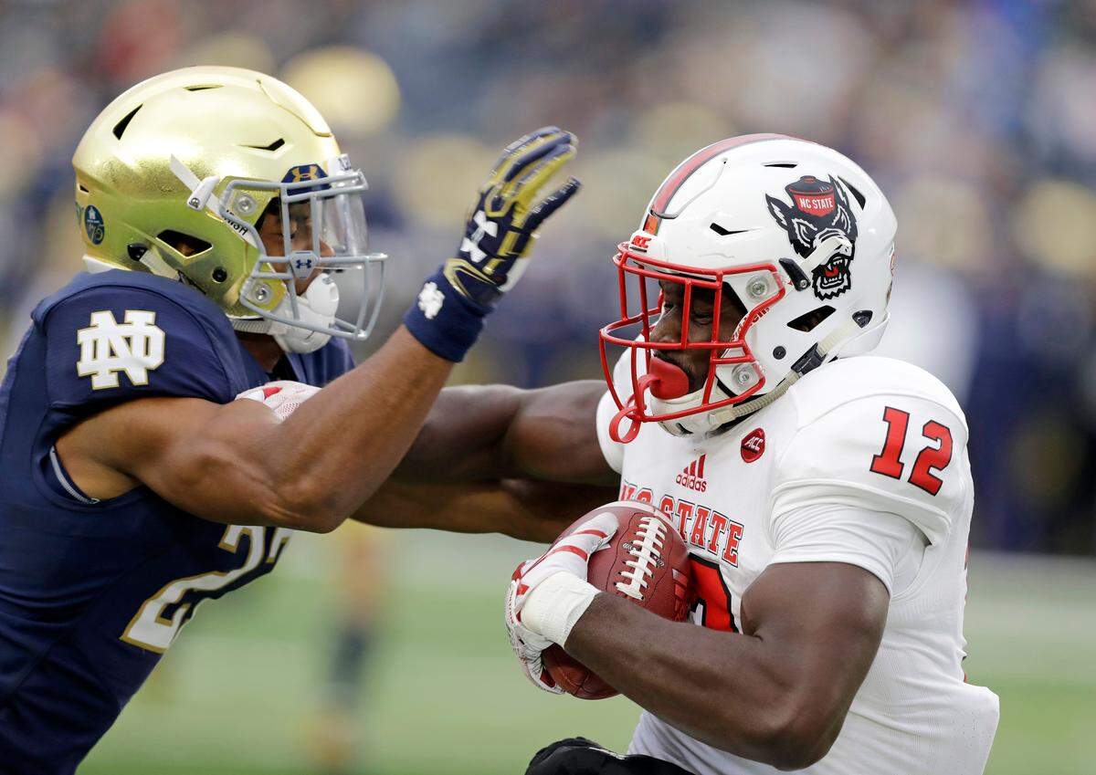 North Carolina State’s Stephen Louis (12) makes a catch against Notre Dame’s Julian Love during the first half of an NCAA college football game, Saturday, Oct. 28, 2017, in South Bend, Ind.