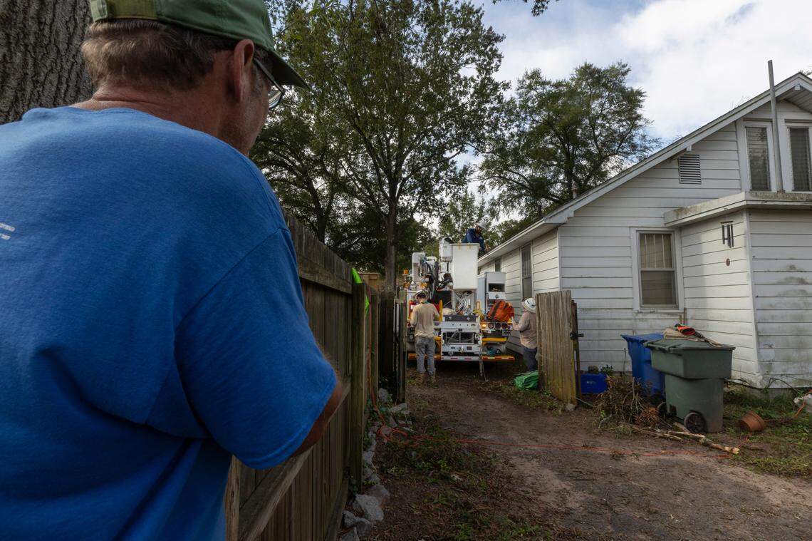 Karl Kinard watches as a power crew finishes their work in a neighbor’s yard. Kindard and several others were without power almost a week after Hurricane Helene knocked out power in Earlewood.