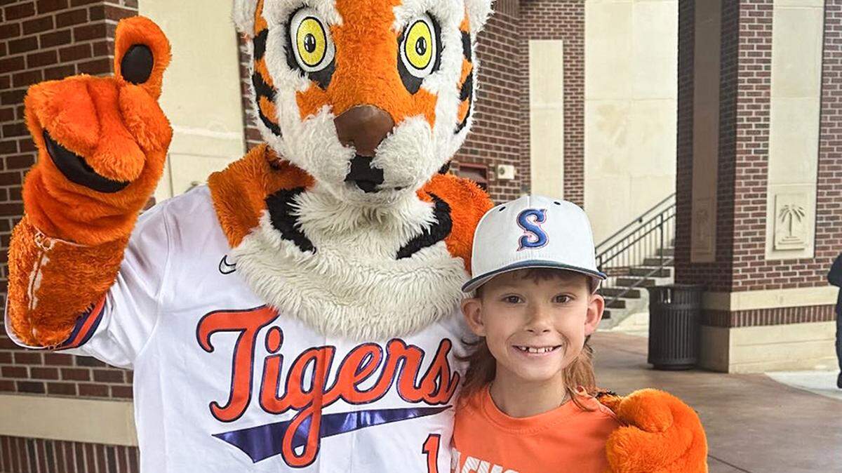 Mason Smith of Lexington died on April 13, 2024, at age 10. He was a huge Clemson baseball and is pictured here with The Tiger, Clemson’s mascot, at a baseball home game at Doug Kingsmore Stadium in late March 2024.