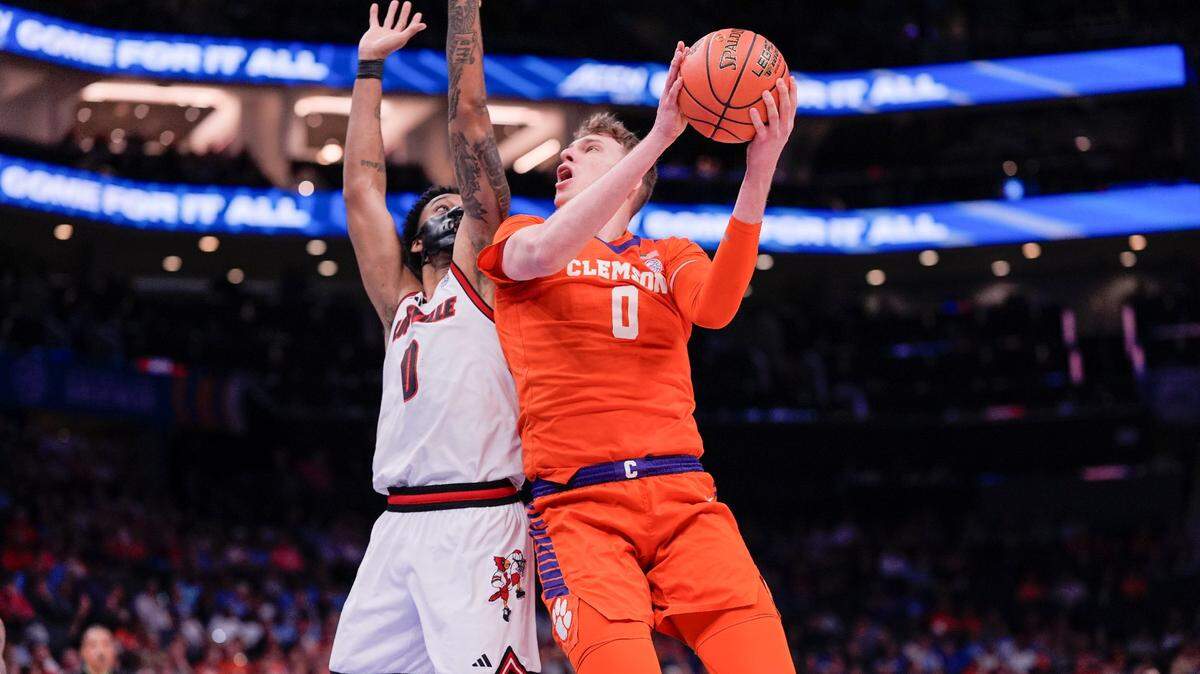 Mar 14, 2025; Charlotte, NC, USA; Clemson Tigers center Viktor Lakhin (0) goes to the basket against Louisville Cardinals forward James Scott (0) during the first half at Spectrum Center.
