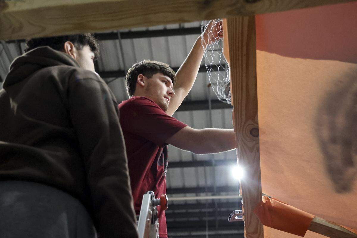 Freshmen engineering students and members of the American Society of Mechanical Engineers (ASME) Lucas Valera, left, and Paxton Elrod attach chicken wire to the outside of the tiger head while finishing the 30-foot effigy of a Clemson Tiger on Monday, Nov. 17, 2025. The tiger is burned at a pep rally prior to the USC vs Clemson rivalry football game.