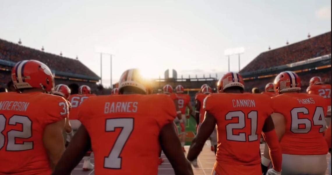 Virtual Clemson football players, including safety Khalil Barnes (7) and offensive lineman Walker Parks (64), gather at the top of The Hill atop Memorial Stadium’s east end zone in an EA Sports College Football 25 screenshot.