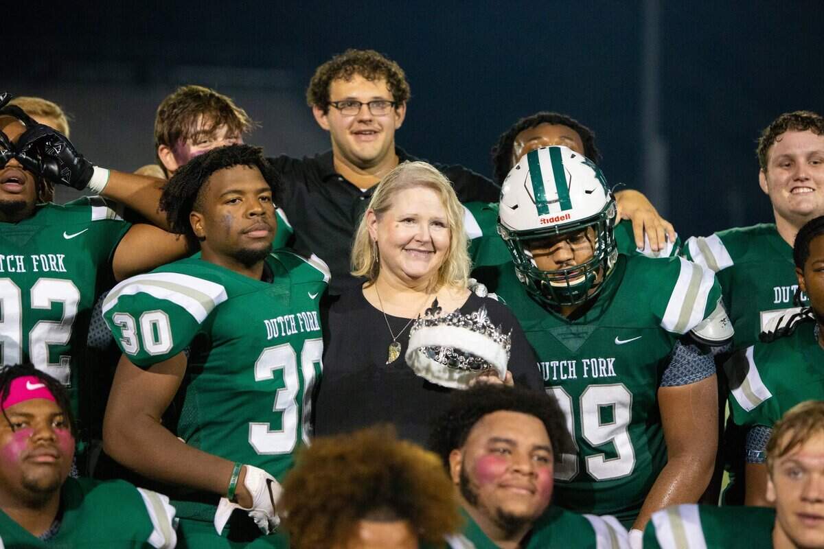 Kelly Hewins Alkhatib, front, poses with the Dutch Fork football team during the 2021 game against River Bluff when Alkhatib’s son, Jack, was named the school’s homecoming king. Jack Alkhatib died in August at a football practice.