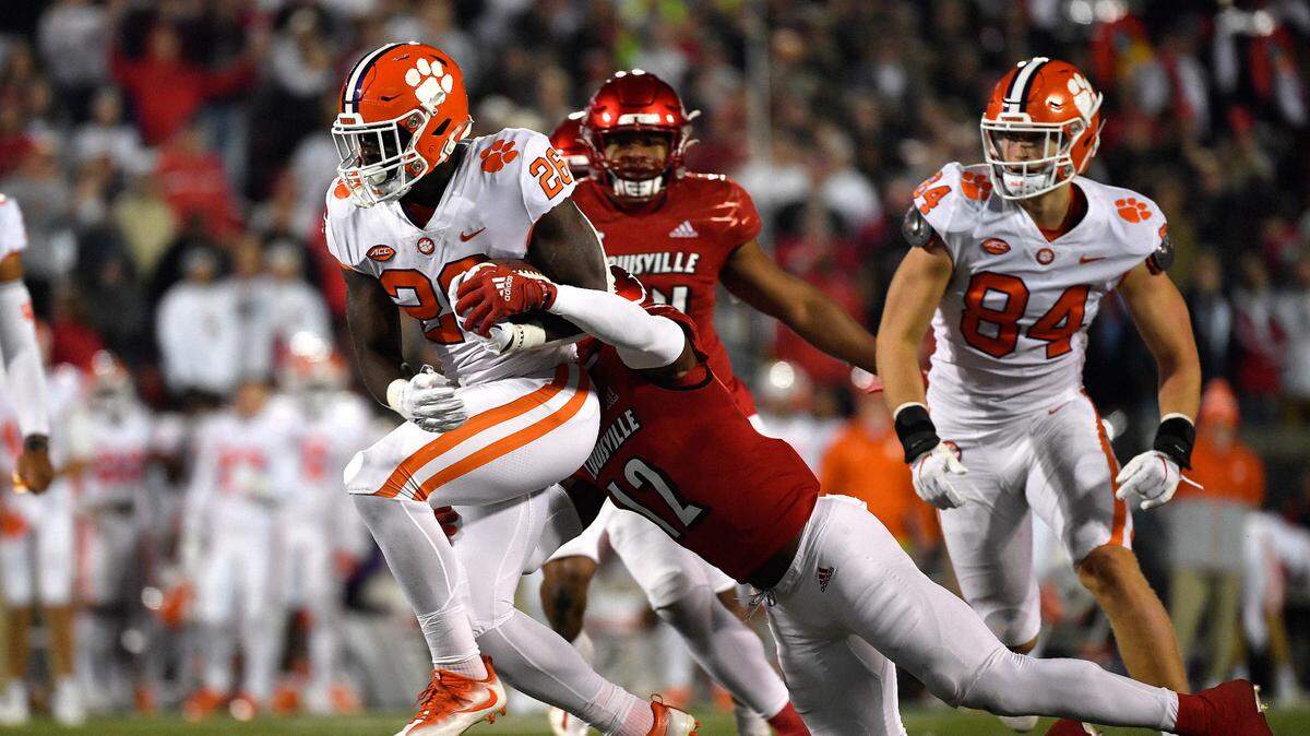 Clemson running back Phil Mafah (26) is tackled by Louisville defensive back Qwynnterrio Cole (12) during the second half of an NCAA college football game in Louisville, Ky., Saturday, Nov. 6, 2021. Clemson won 30-24.
