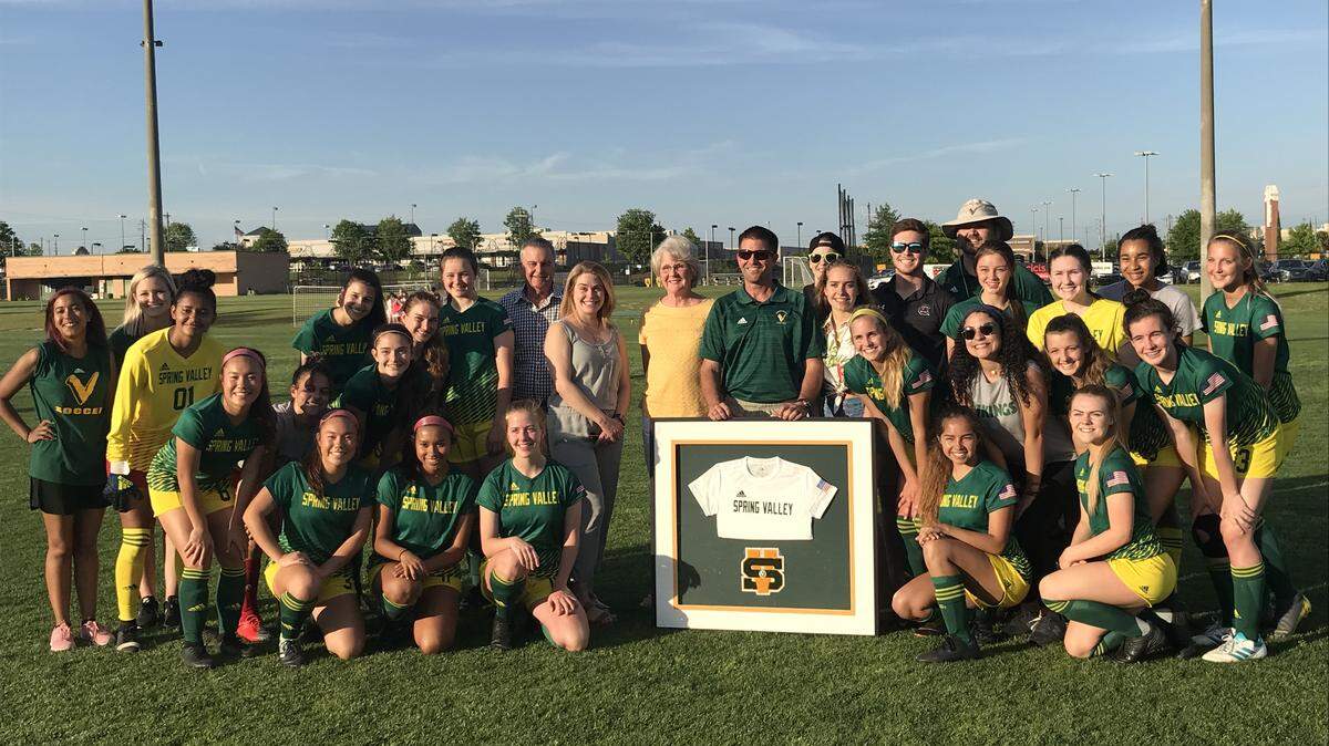 Spring Valley girls soccer coach Steve Lea poses with his team during a pre-game ceremony Tuesday. Lea is retiring at the end of the season.