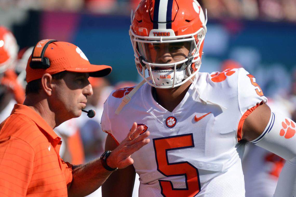 Sep 25, 2021; Raleigh, North Carolina, USA; Clemson Tigers head coach Dabo Swinney (left) talks to quarterback DJ Uiagalelei (5) prior to a game against the North Carolina State Wolfpack at Carter-Finley Stadium. Mandatory Credit: Rob Kinnan-USA TODAY Sports