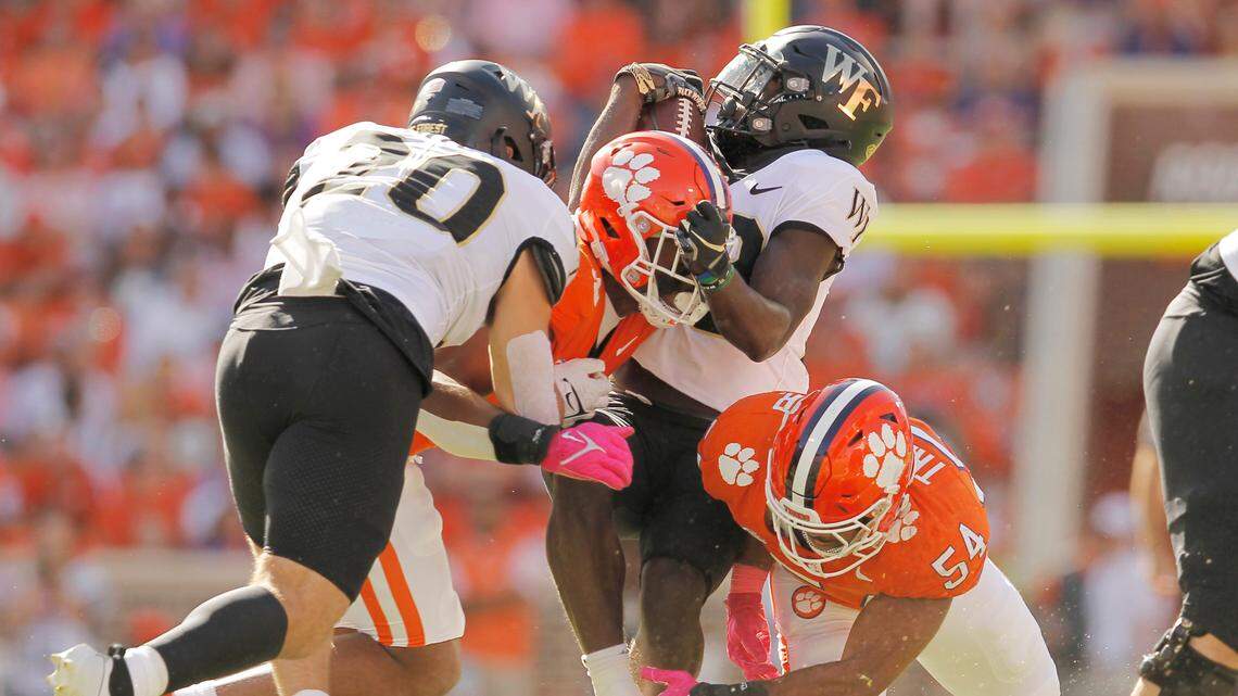 Wake Forest running back Demond Claiborne (23) gets pulled down by Clemson defensive end Justin Mascoll (7) and Clemson linebacker Jeremiah Trotter Jr. (54) during first-half action in Clemson, S.C. on Saturday, Oct. 7, 2023. (Travis Bell/SIDELINE CAROLINA)