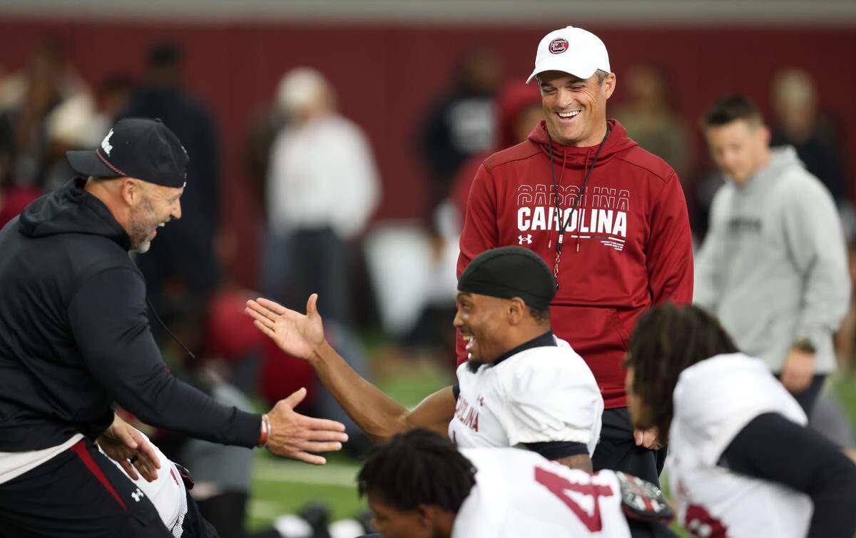 South Carolina head coach Shane Beamer laughs with passing game coordinator Mike Furrey and defensive back Gerald Kilgore (1) during practice in Columbia on Wednesday, March 18, 2026.