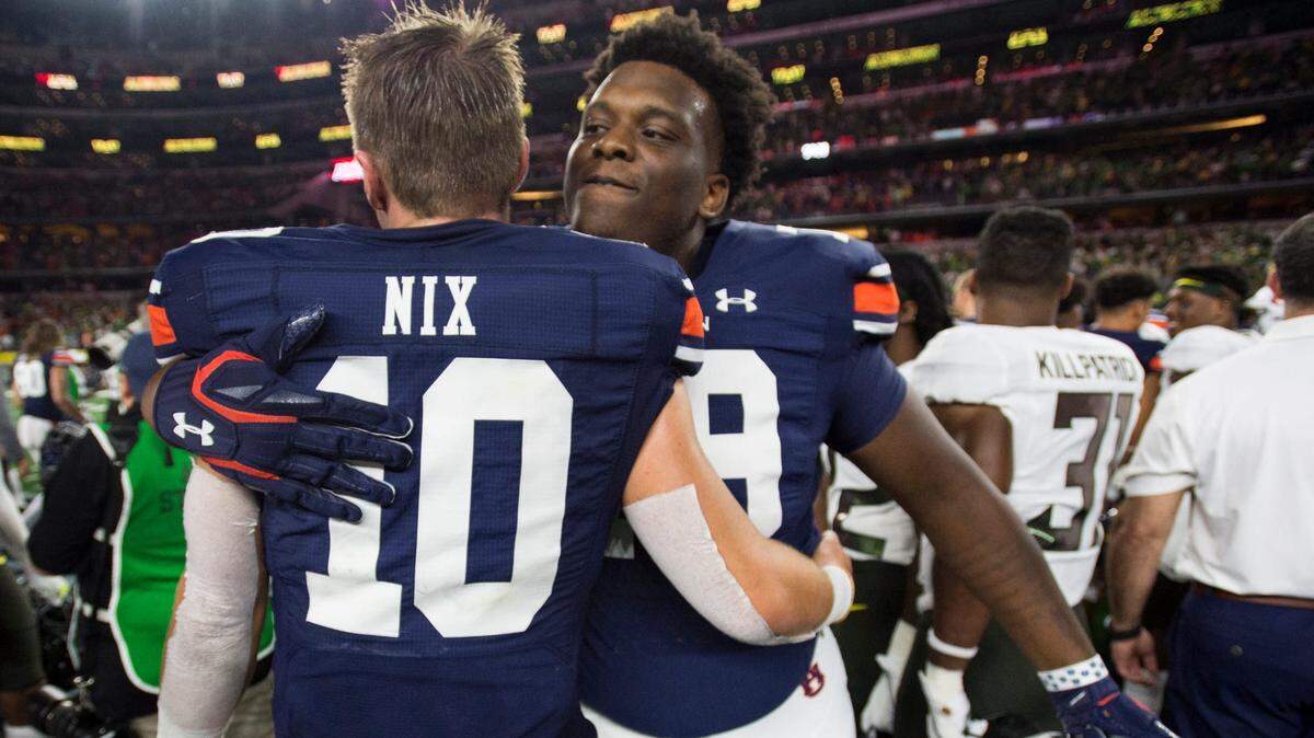 Auburn quarterback Bo Nix (10) and Auburn offensive lineman Kamaar Bell (79) hug after the game at AT&T Stadium on Aug. 31, 2019. Auburn defeated Oregon 27-21.