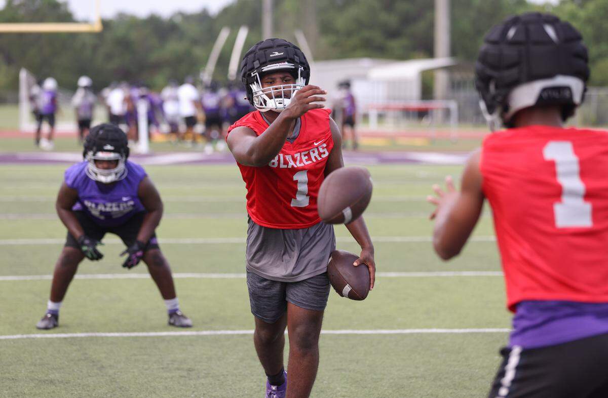 Quarterback Breylon Boyd tosses Tre Howard a ball while running drills during the first day of practice at Ridge View High School in Columbia on Friday, July 28, 2023.