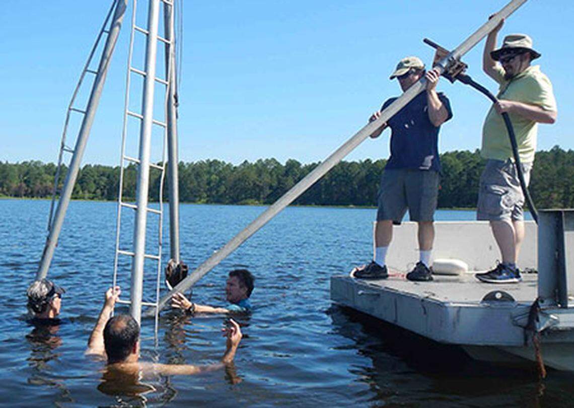 Archaelogist Christopher Moore from the University of South Carolina (second from right) and several colleagues at White Pond near Elgin, South Carolina collecting underwater core samples.
