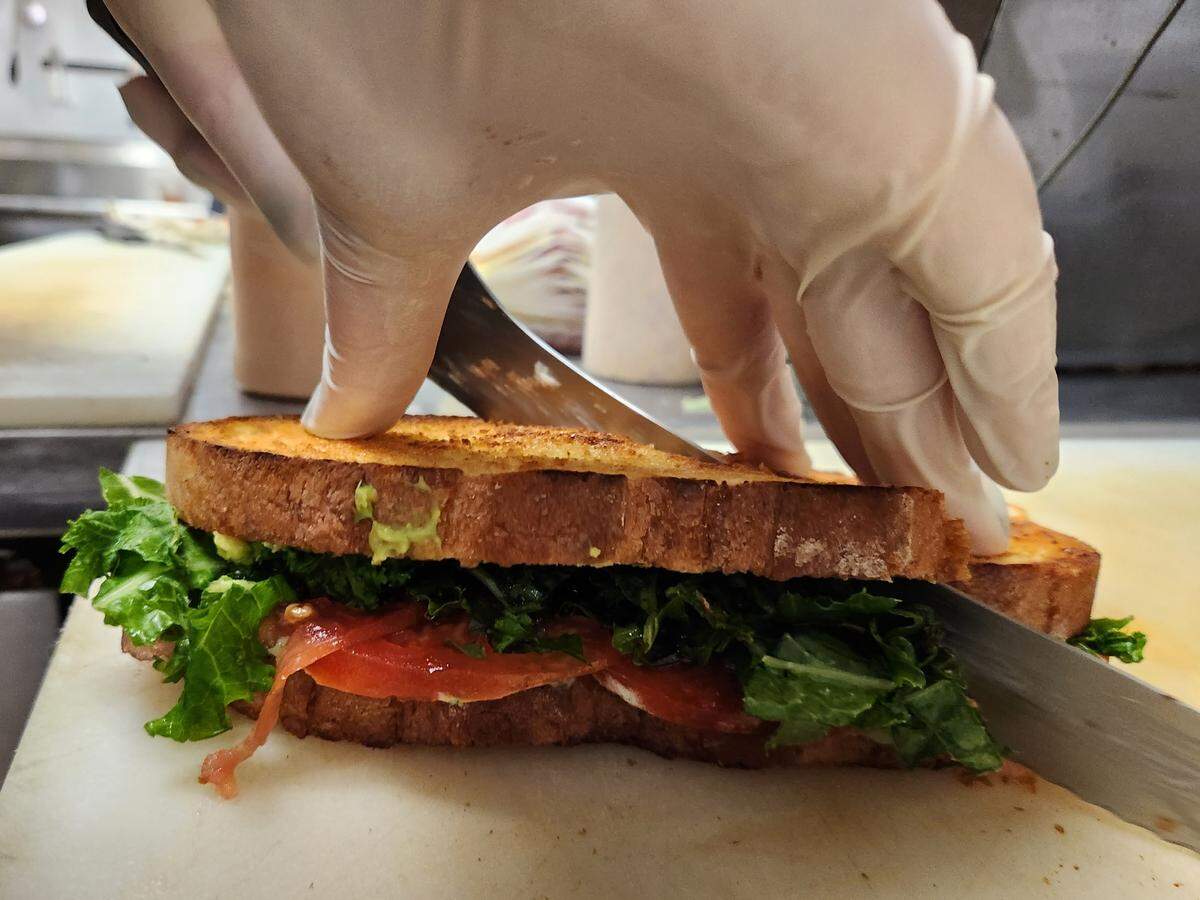 A sandwich gets cut at Crave Artisan Market.