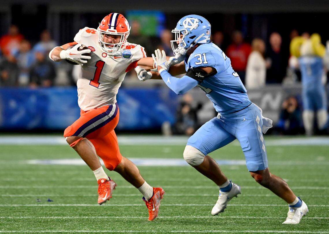 Dec 3, 2022; Charlotte, North Carolina, USA; Clemson Tigers running back Will Shipley (1) stiff arms North Carolina Tar Heels defensive back Will Hardy (31) during the first quarter of the ACC Championship game at Bank of America Stadium. Mandatory Credit: Bob Donnan-USA TODAY Sports