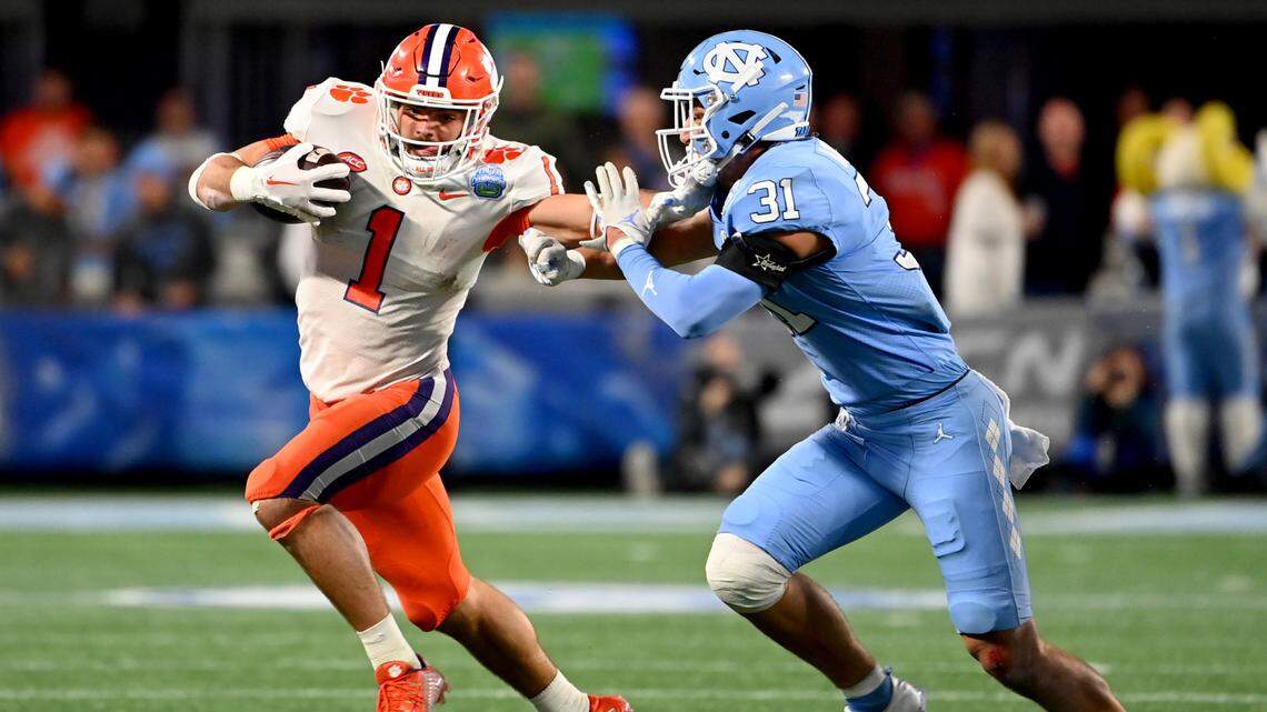 Dec 3, 2022: Clemson Tigers running back Will Shipley (1) stiff arms North Carolina Tar Heels defensive back Will Hardy (31) during the first quarter of the ACC Championship game at Bank of America Stadium.
