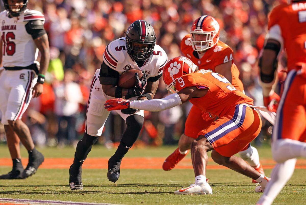 South Carolina running back Raheim Sanders (5) carries the ball as Clemson safety R.J. Mickens (9) comes in to make the tackle during the first half of the Palmetto Bowl between South Carolina and Clemson at Memorial Stadium in Clemson on Saturday, November 30, 2024.
