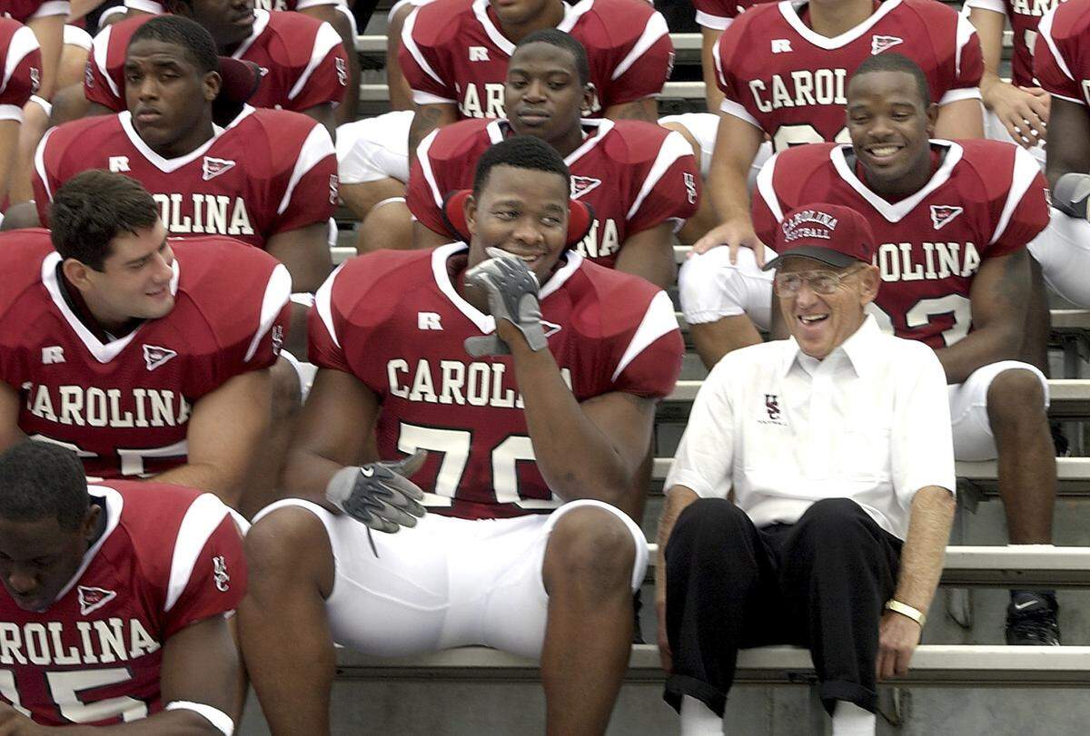 Coach Lou Holtz jokes with offensive lineman Na'shan Goddard before the team picture was taken on media day on Aug. 8, 2003.. When Holtz was told to join the other coaches on the top row, Holtz told the photographer, "Goddard ask me to sit here." 
