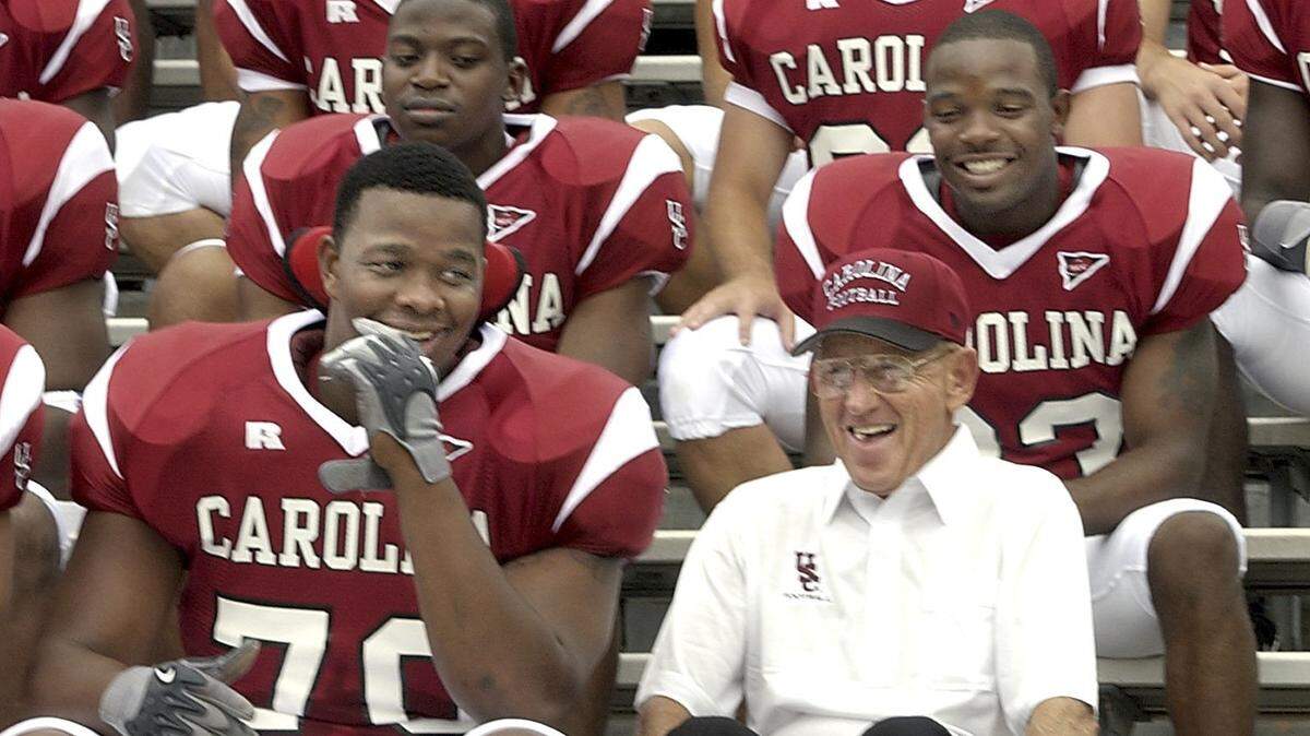 Coach Lou Holtz jokes with offensive lineman Na’shan Goddard before the team picture was taken on media day on Aug. 8, 2003.. When Holtz was told to join the other coaches on the top row, Holtz told the photographer, “Goddard ask me to sit here.”