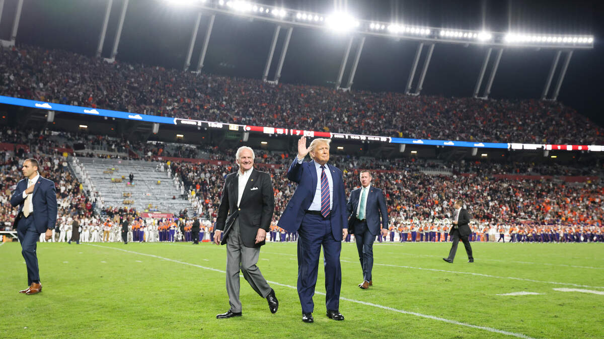 Former President Donald Trump and Governor Henry McMaster walk out onto the field during halftime of South Carolina’s game against Clemson at Williams-Brice Stadium in Columbia on Saturday, November 25, 2023.
